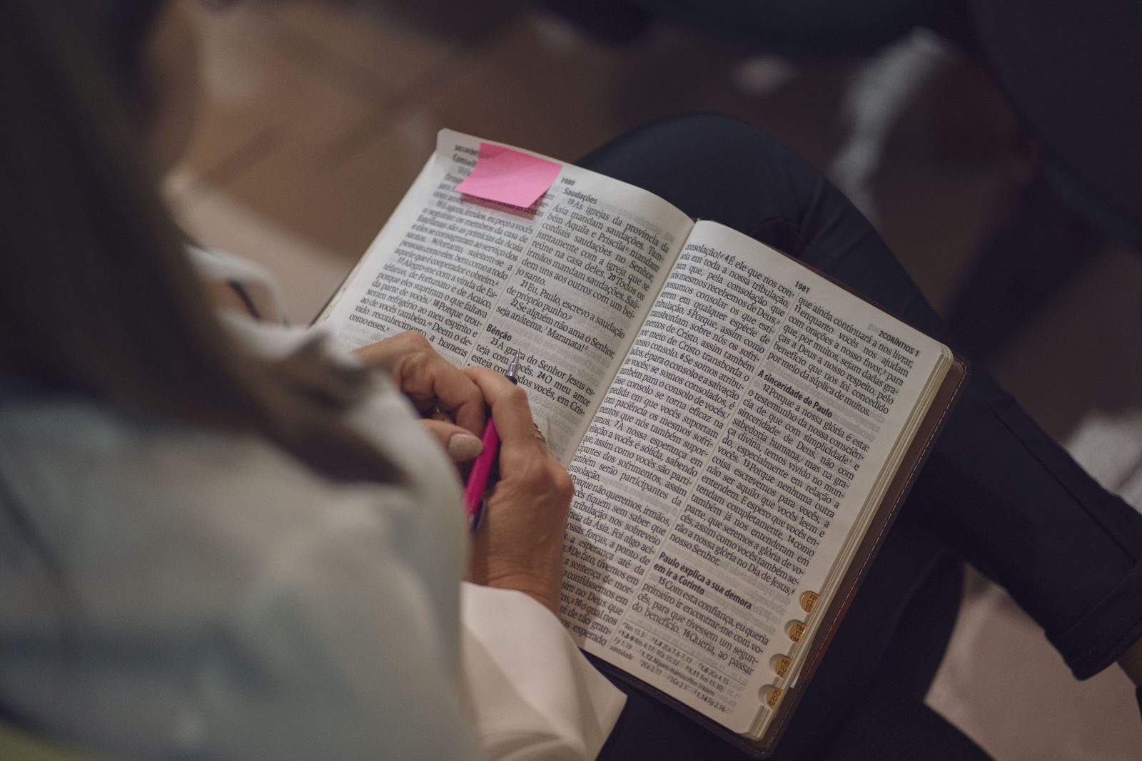 Woman studying the Bible with a note marker, stock photograph