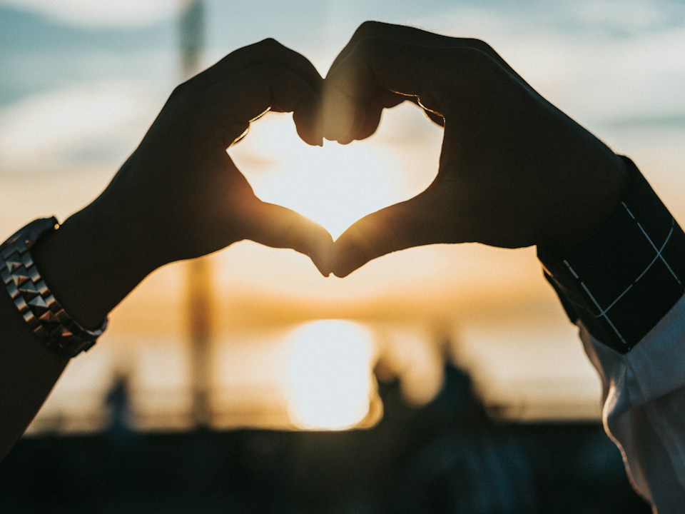 Two people making a heart together with their hands, stock photograph