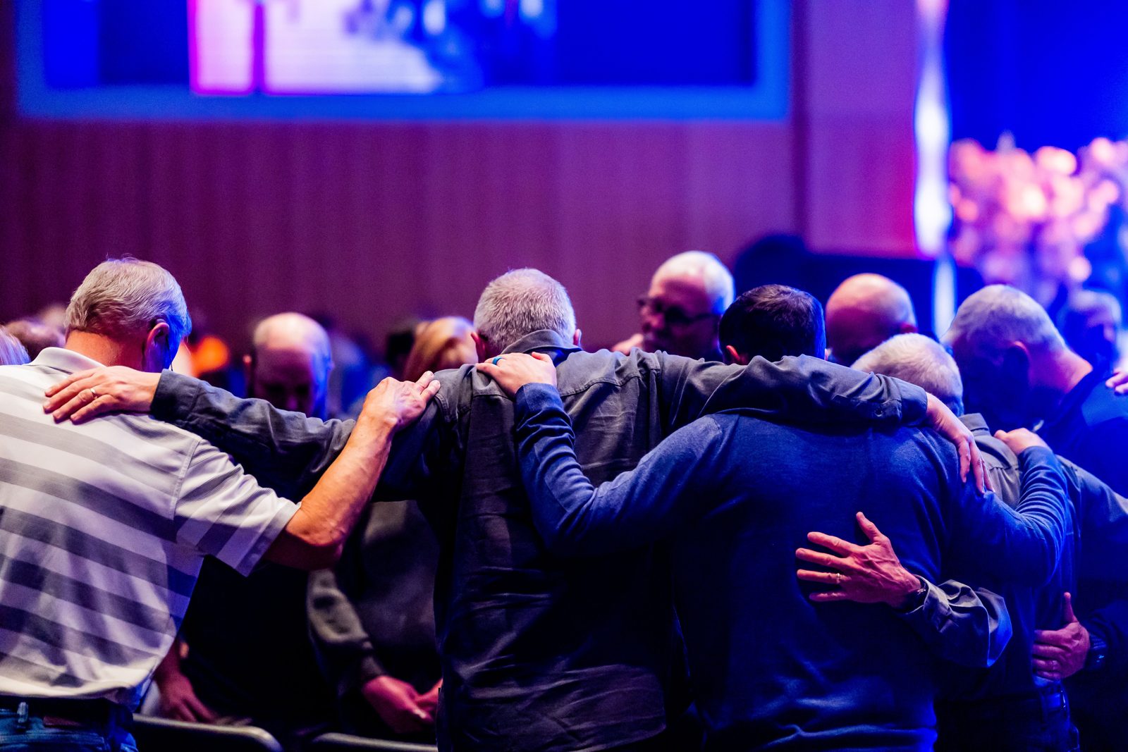 Men praying together at a Christian gathering, stock photograph